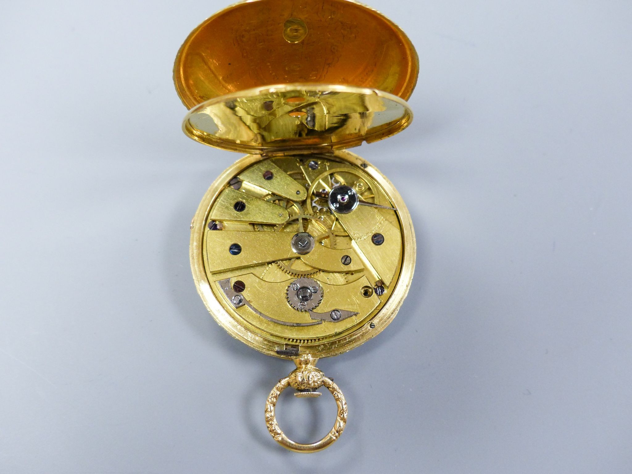 A cased 19th century continental engraved yellow metal open faced fob watch, case diameter 36mm, gross weight 26.6 grams, with watch key.